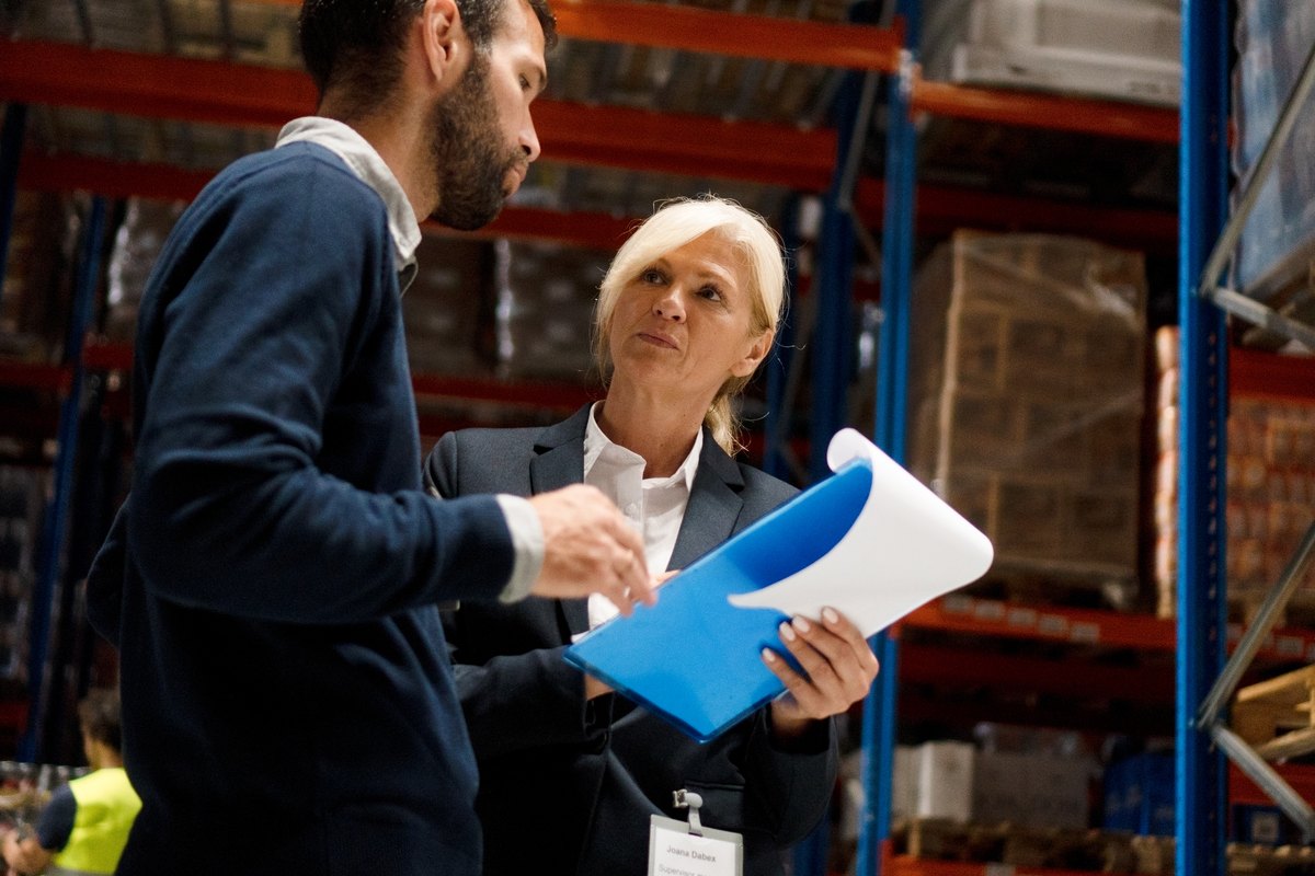 Supplier representative reviewing inventory with a warehouse supervisor